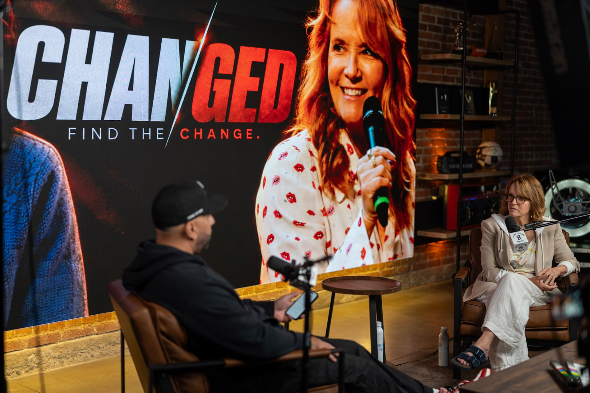 Wide view of Brian interviewing a guest in the studio