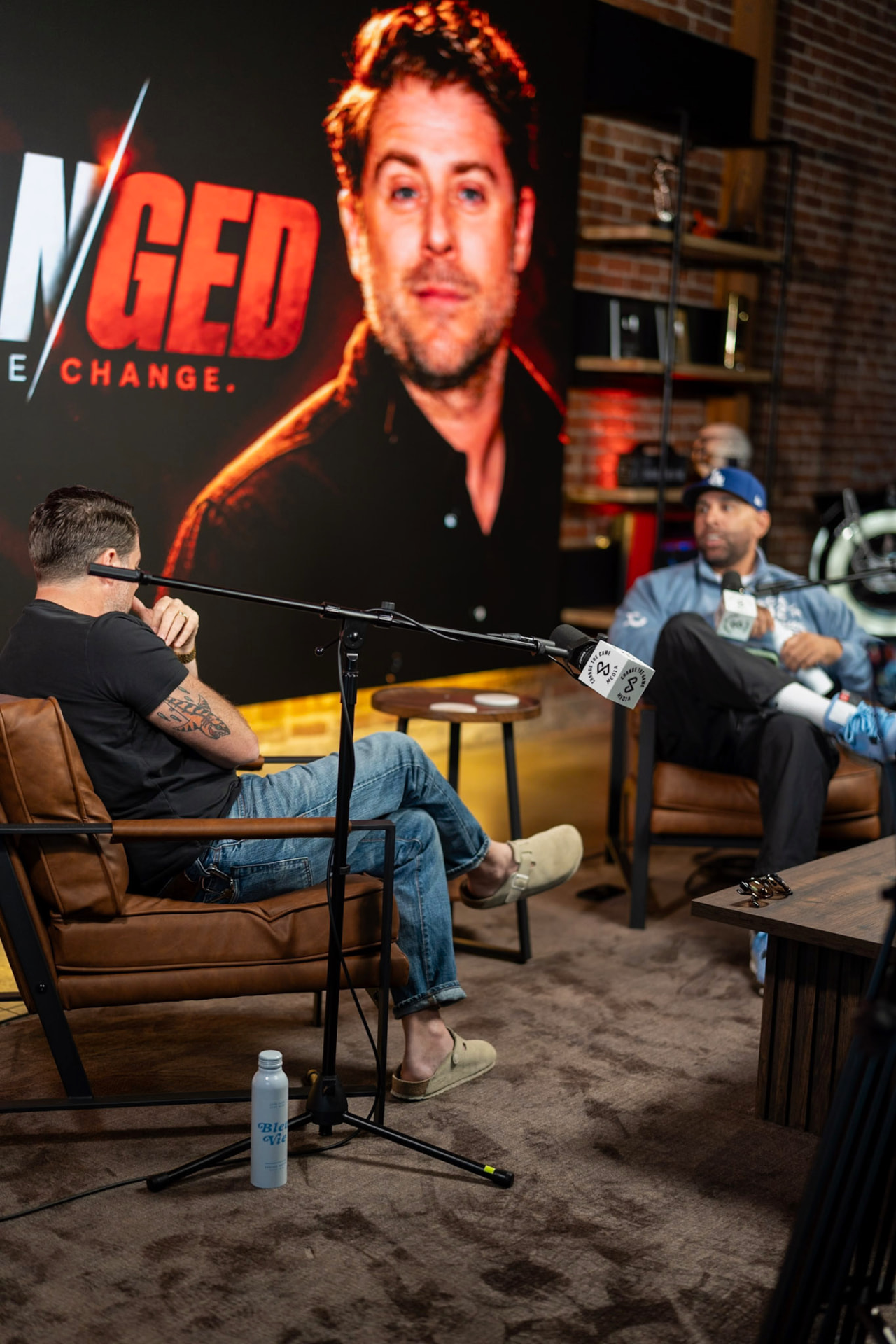 Brian interviewing a guest in the brick-walled studio